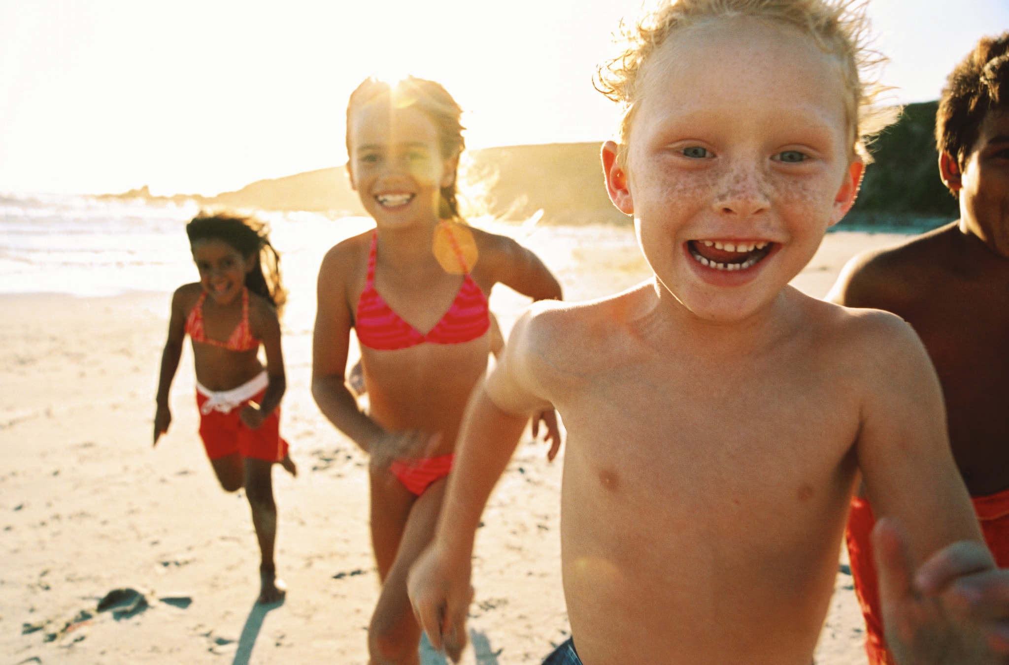 Kids running on the beach smiling!