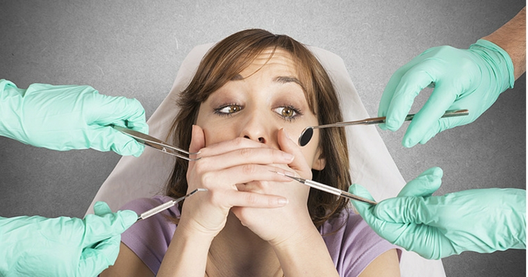 woman surrounded by dental instruments showing dental anxiety